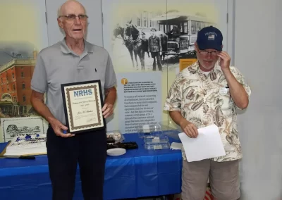 Chapter Membership Chairman Tom Cook (right) presents the NRHS 60 Year Membership Certificate and Pin to John Amhrein.