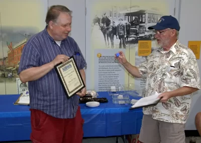 Chapter Membership Chairman Tom Cook (right) presents the NRHS 50 Year Membership Certificate and Pin to Edwin Kraft.