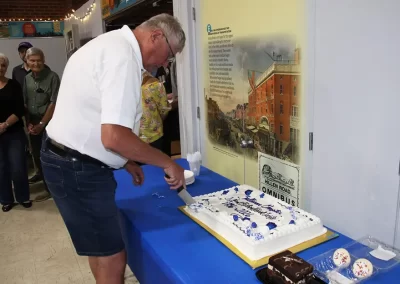 Chapter President Garry Pace cuts the first slice of the 90th anniversary sheet cake.